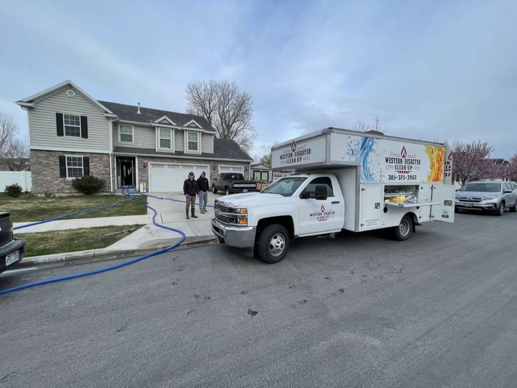 Western Disaster Clean Up crew running water extraction lines at a home